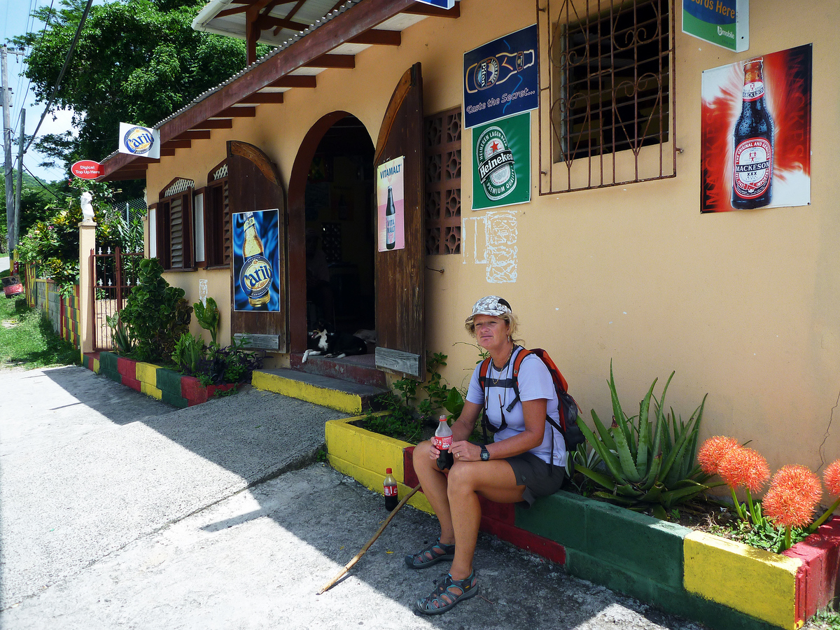 Waiting for a bus outside a rum shop